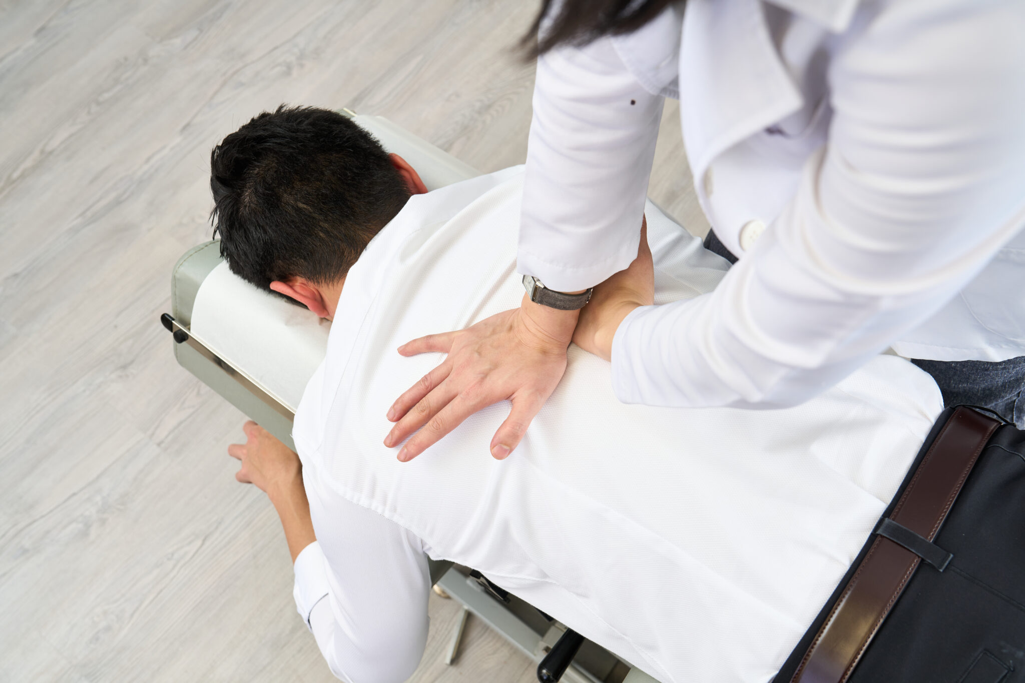Chiropractor assessing a patient's back and hip after a hiking injury in Hong Kong